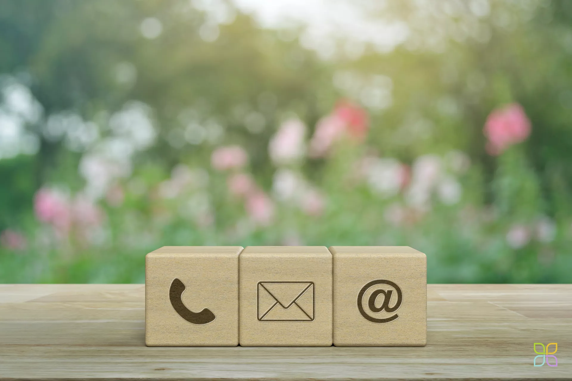 Würfel mit Kontaktmöglichkeiten wie Telefon. E-Mail auf Tischplatte positioniert vor Garten