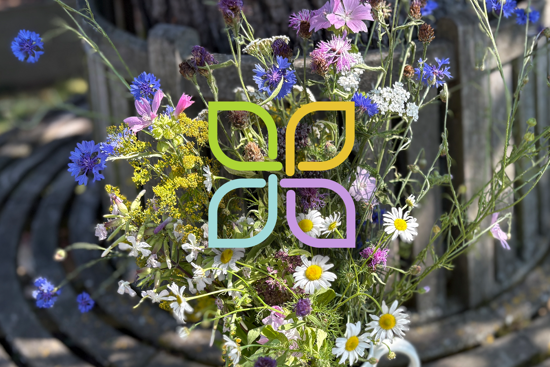 Blumenstrauß auf einer Holzbank mit Logo Lebenspfad