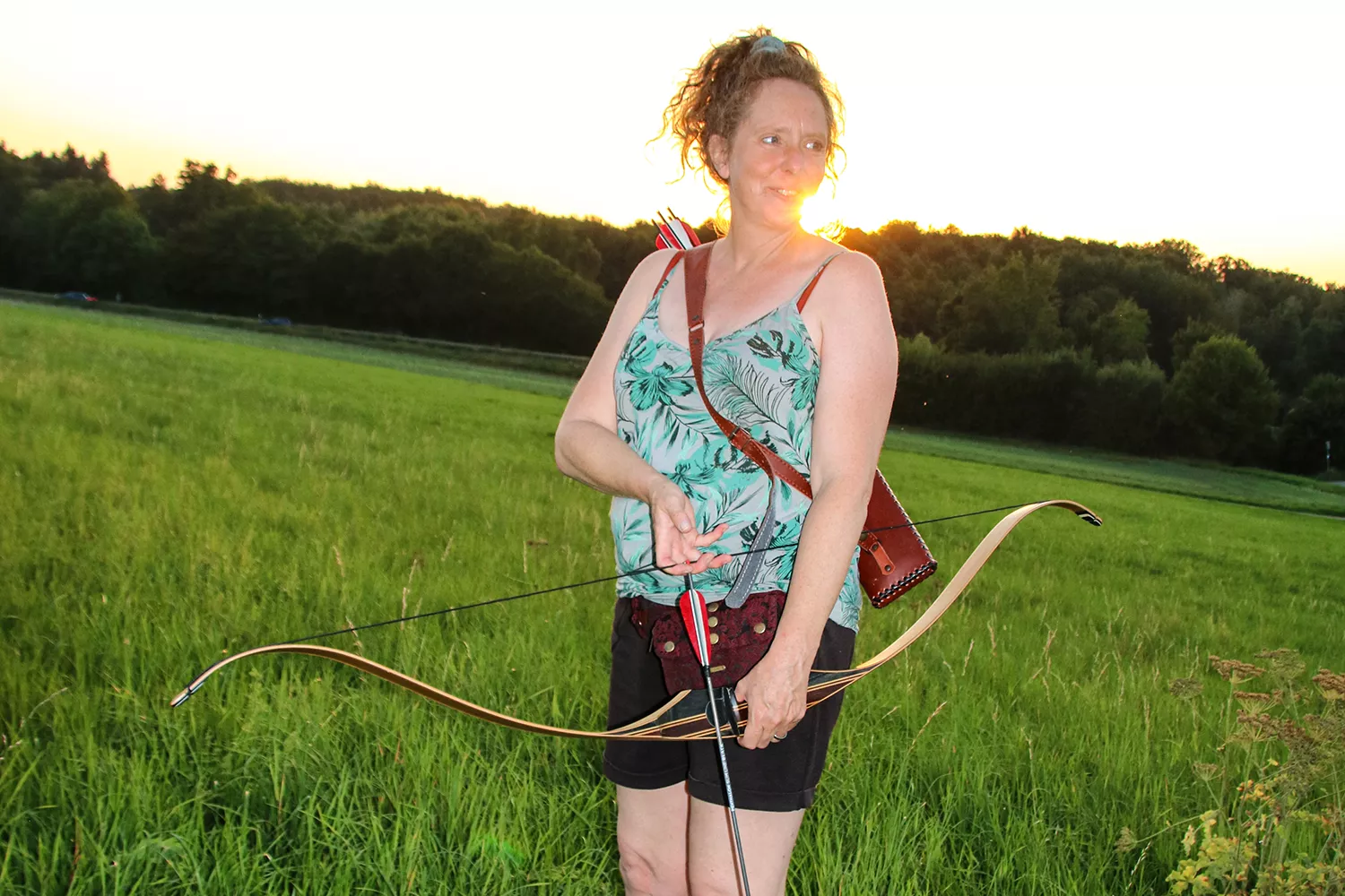 Anja mit Pfeil und Bogen auf Wiese