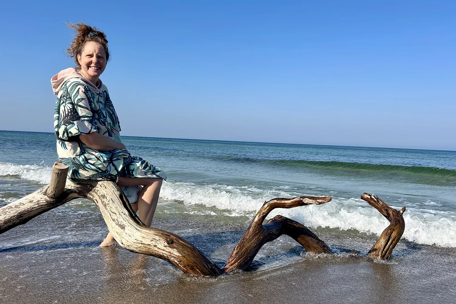 Anja am Meer auf einem Baumstamm sitzend Anja am Meer auf einem Baumstamm sitzend
