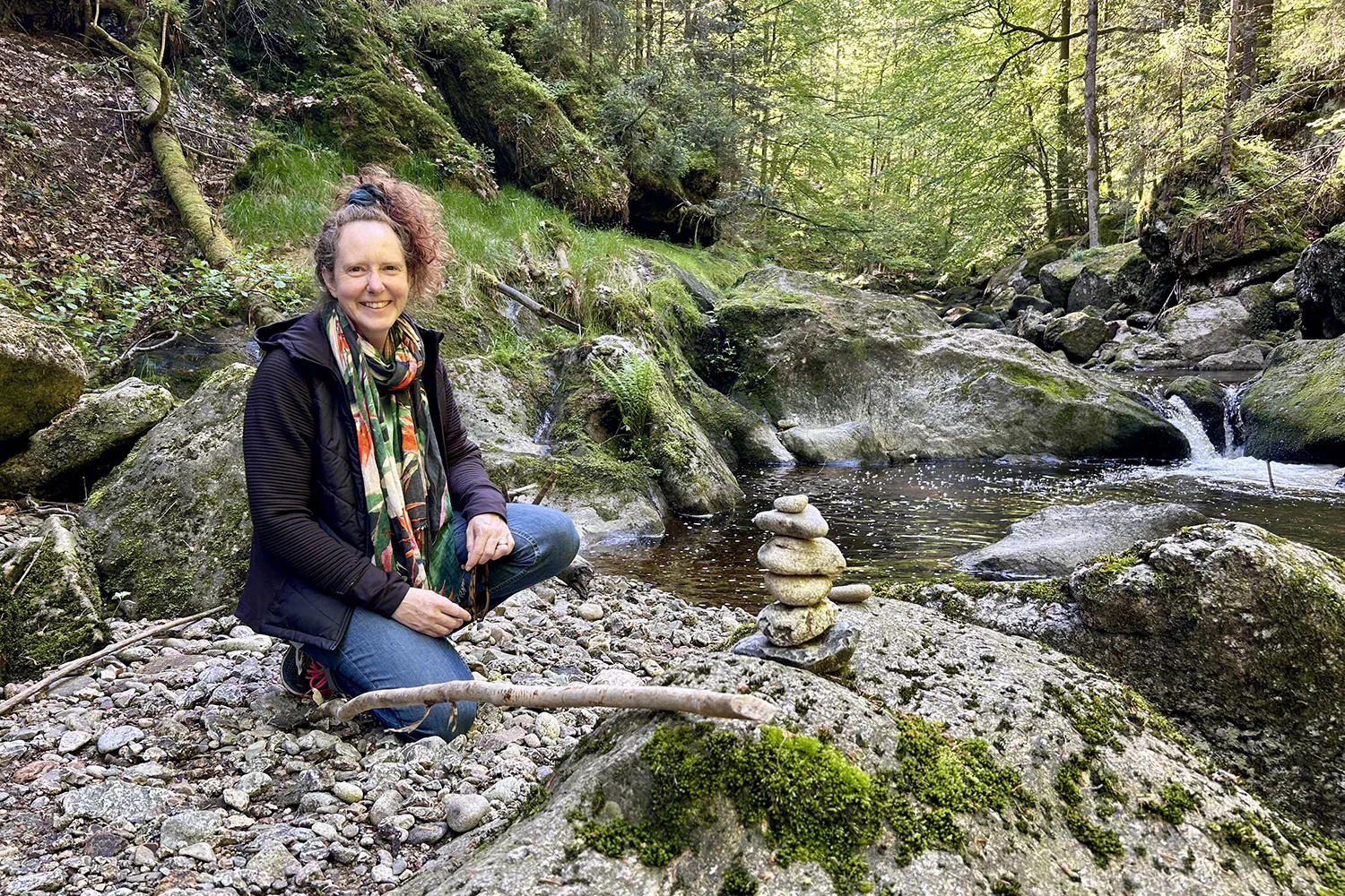 Anja an einem Waldbach mit einer Steinformation Anja an einem Waldbach mit einer Steinformation