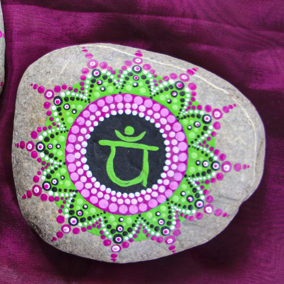 Symbol für Herzchakra mit grünen und rosa Acrylfarben auf Stein gestaltet