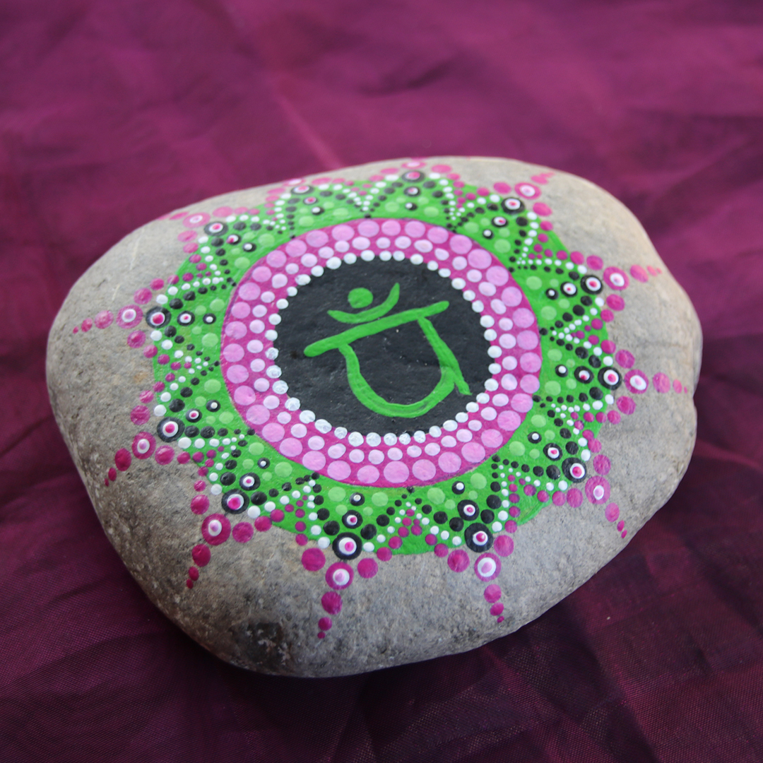 Symbol für Herzchakra mit grünen und rosa Acrylfarben auf Stein gestaltet