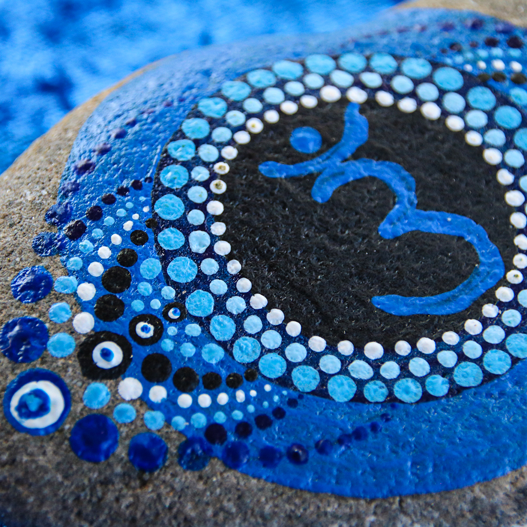 Symbol Stirnchakra in Blautönen mit Acrylfarbe auf Naturstein Nahaufnahme
