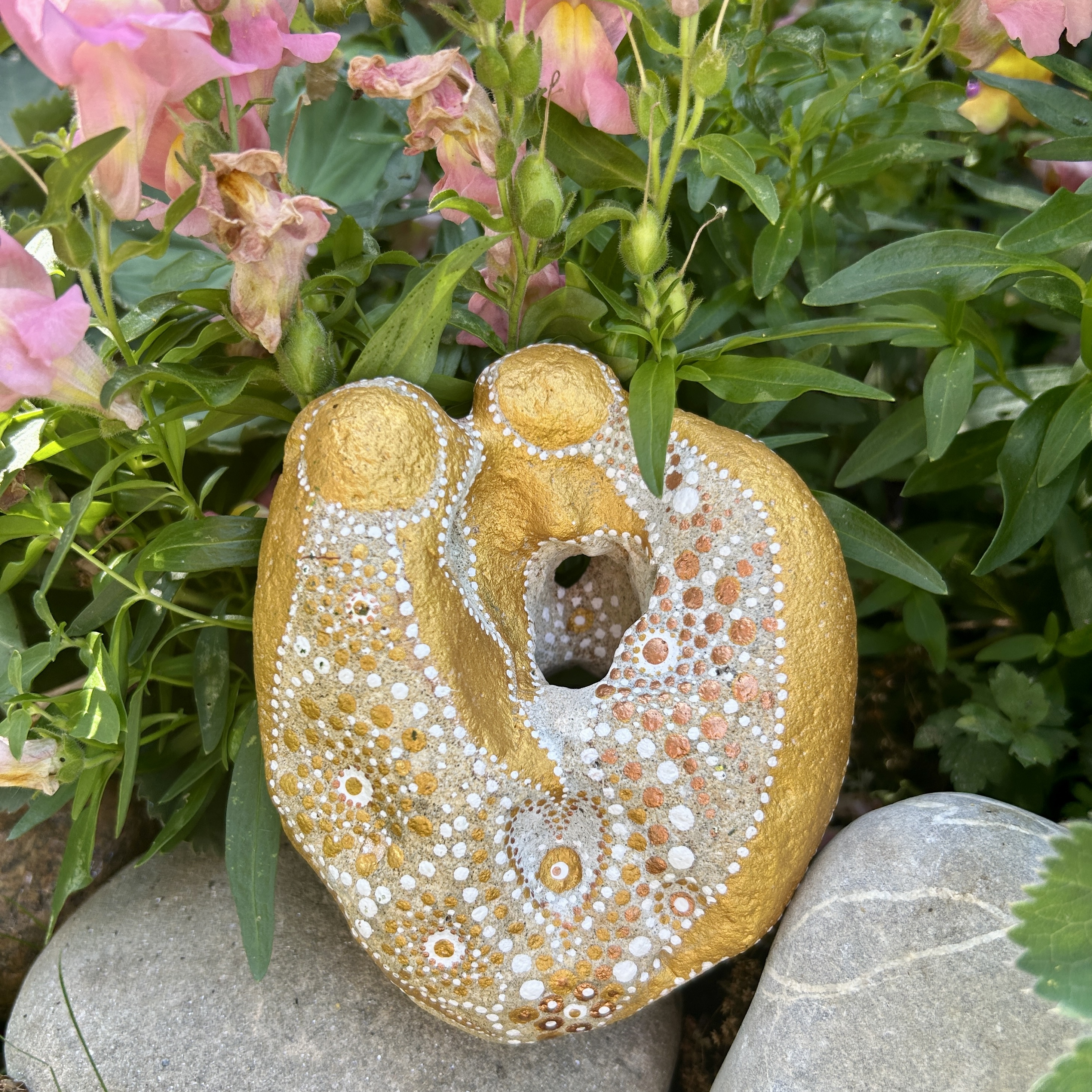 Bemalter Stein mit zwei Engel vor rosa Löwenmäulchen