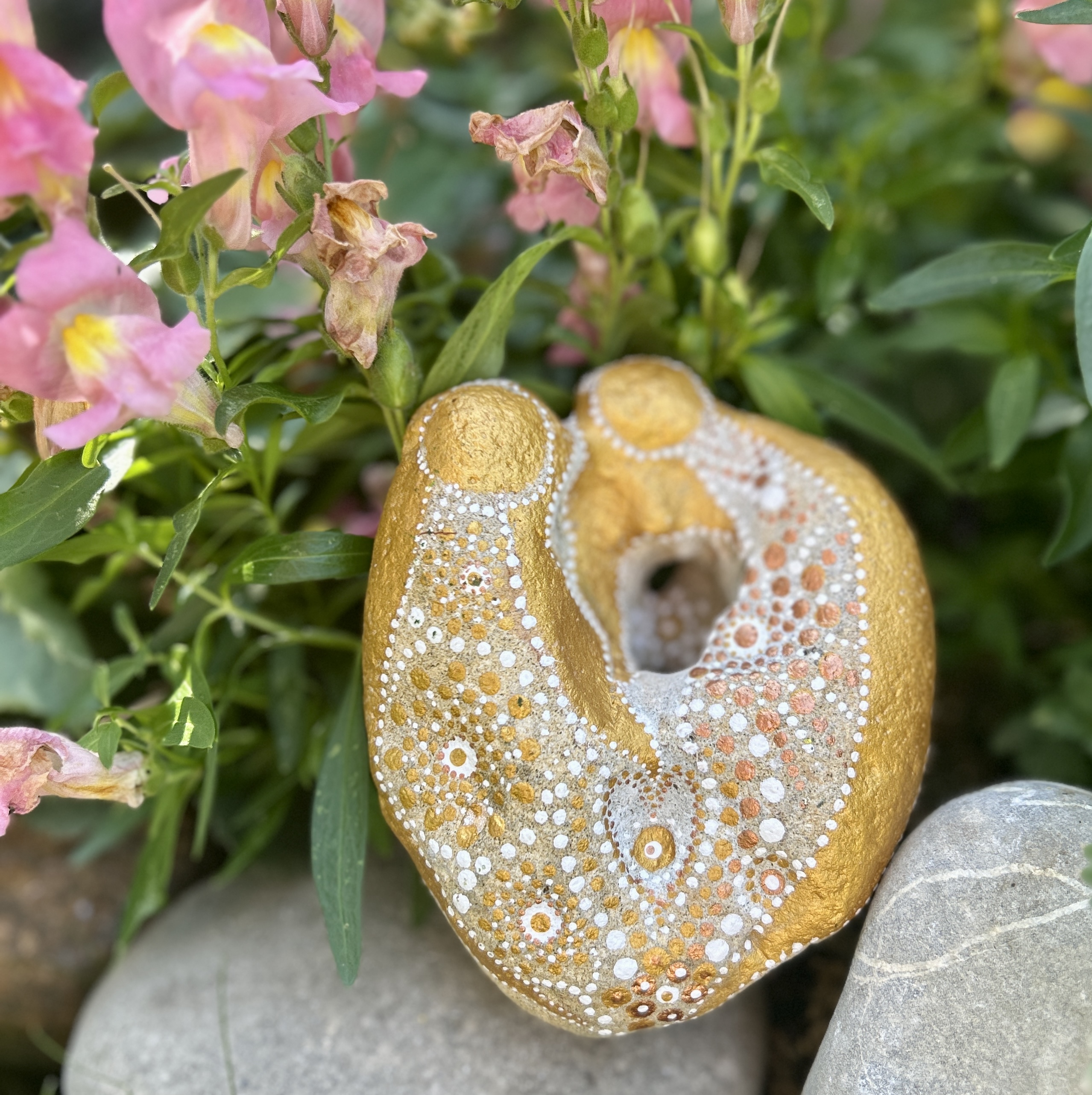 Bemalter Stein mit zwei Engel vor rosa Löwenmäulchen