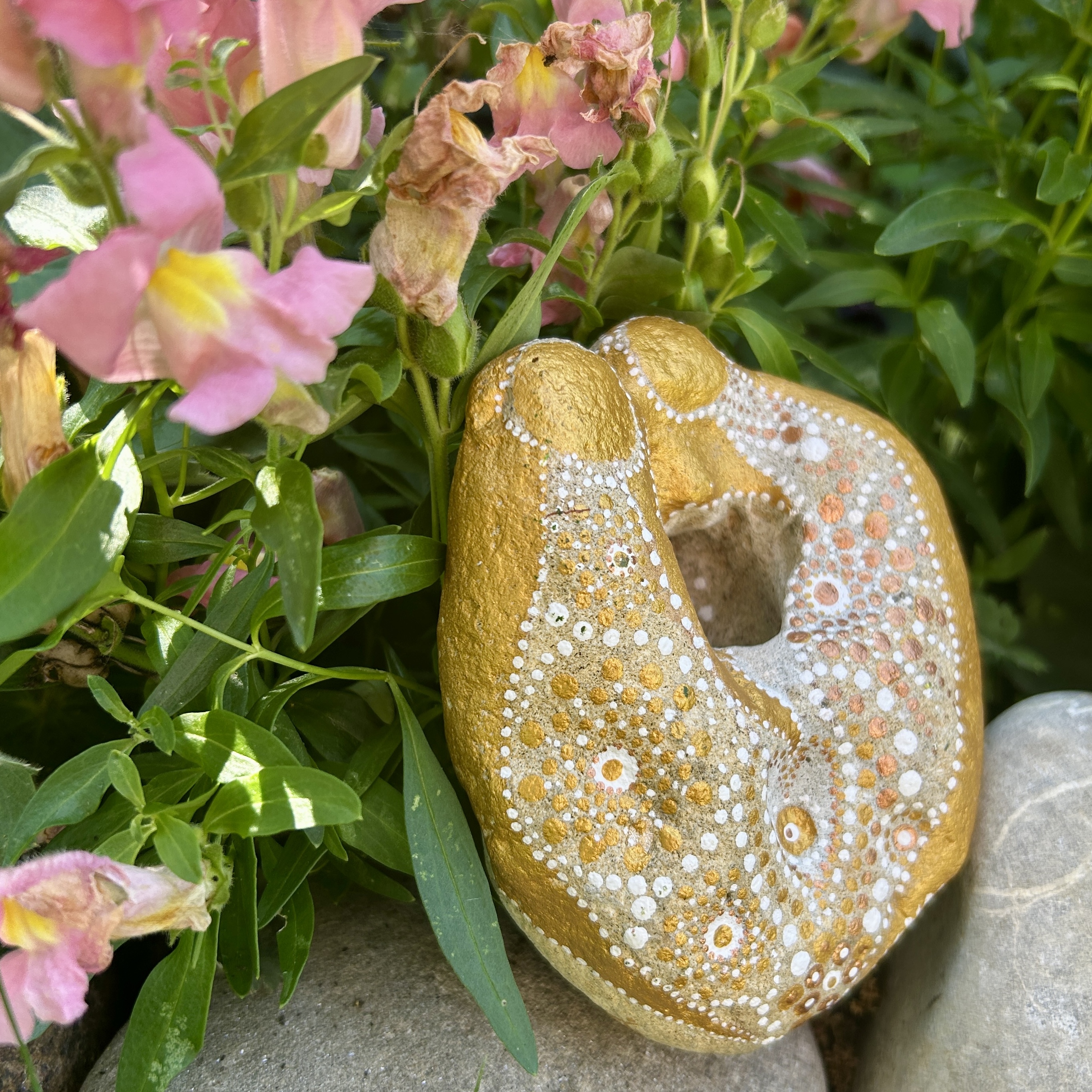 Bemalter Stein mit zwei Engel vor rosa Löwenmäulchen