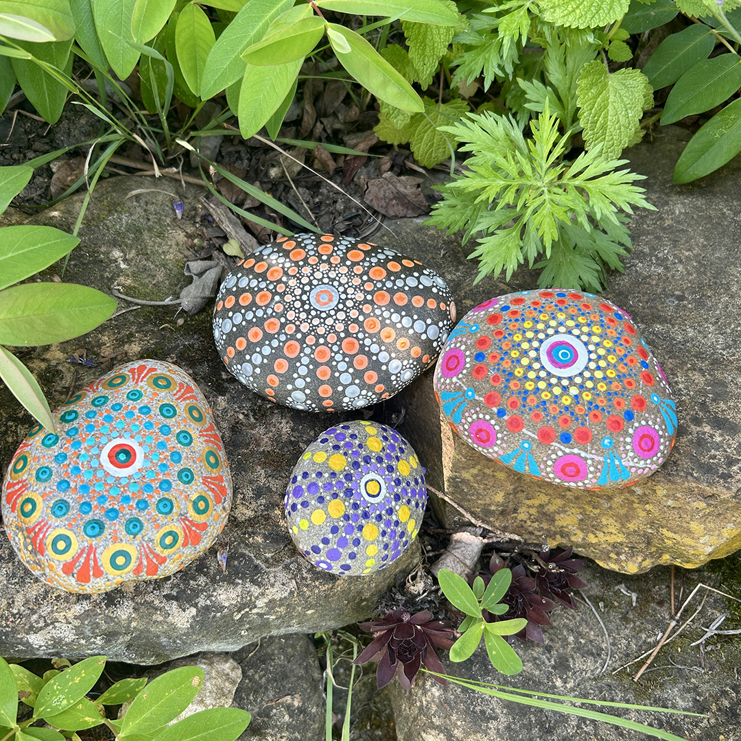 Vier bemalte Steine mit Mandalas