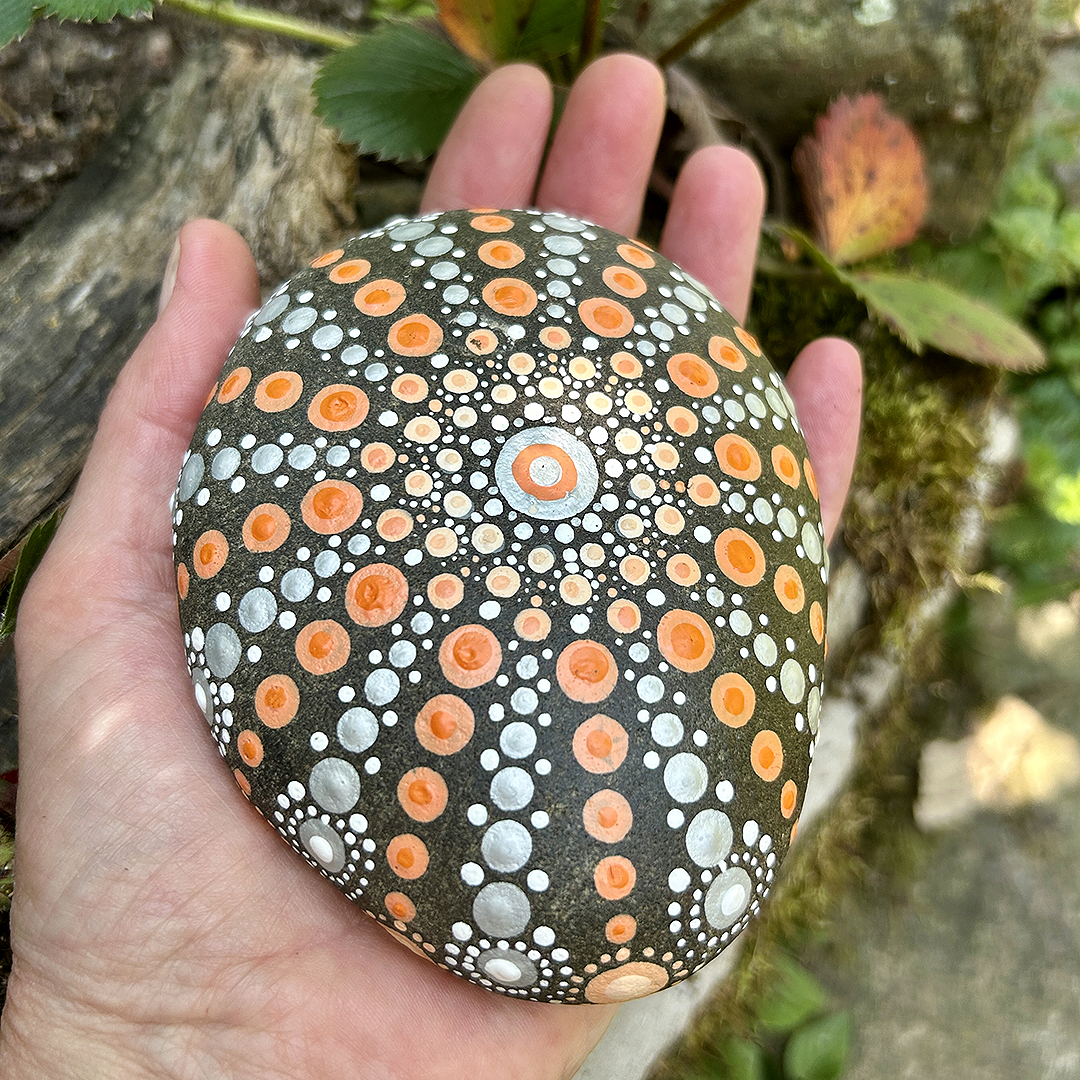 Bemalter Stein mit Mandala in der Hand
