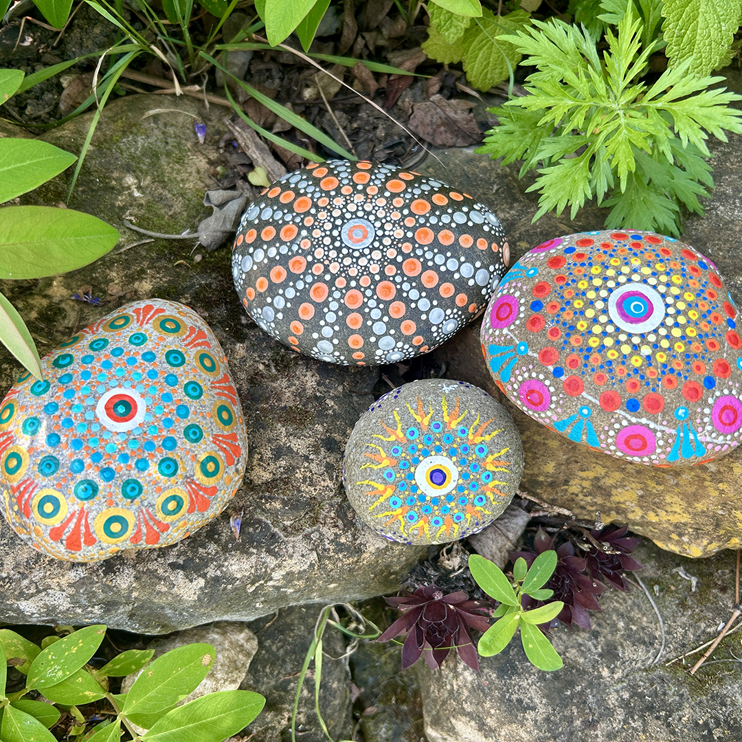 Vier bemalte Steine mit Mandalas
