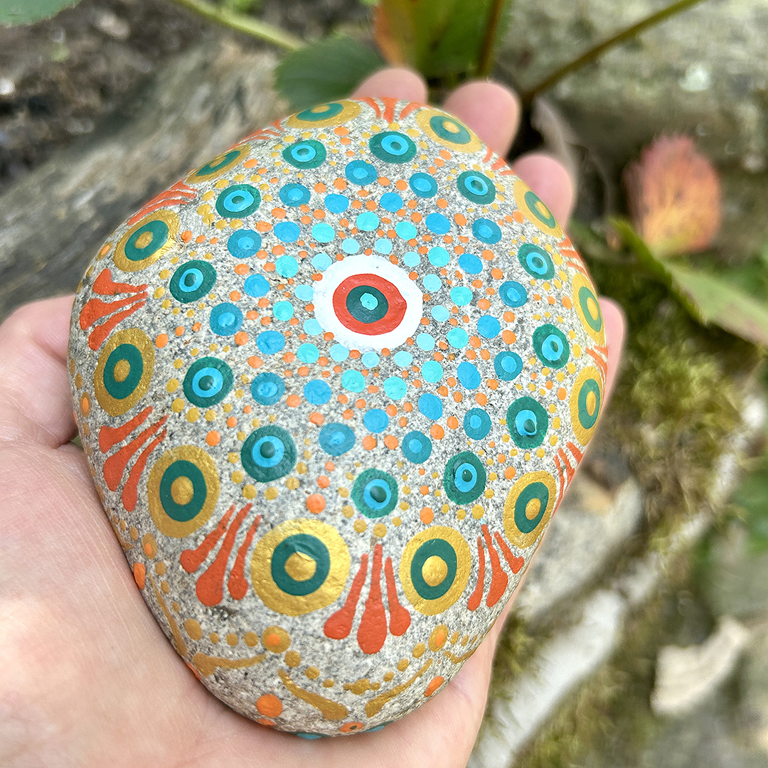 Bemalter Stein mit Mandala in der Hand