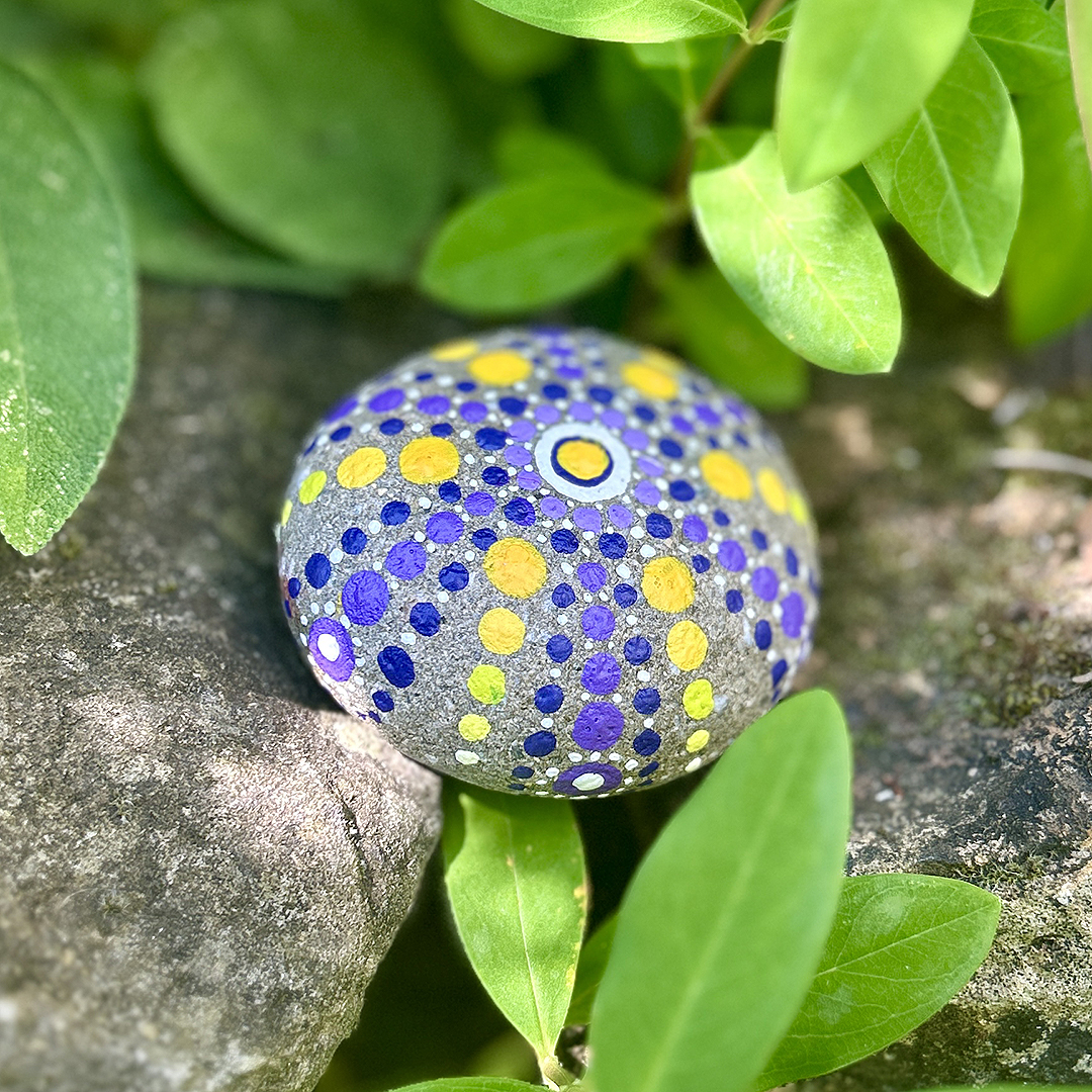 Bemalter Stein mit Mandala in Garten