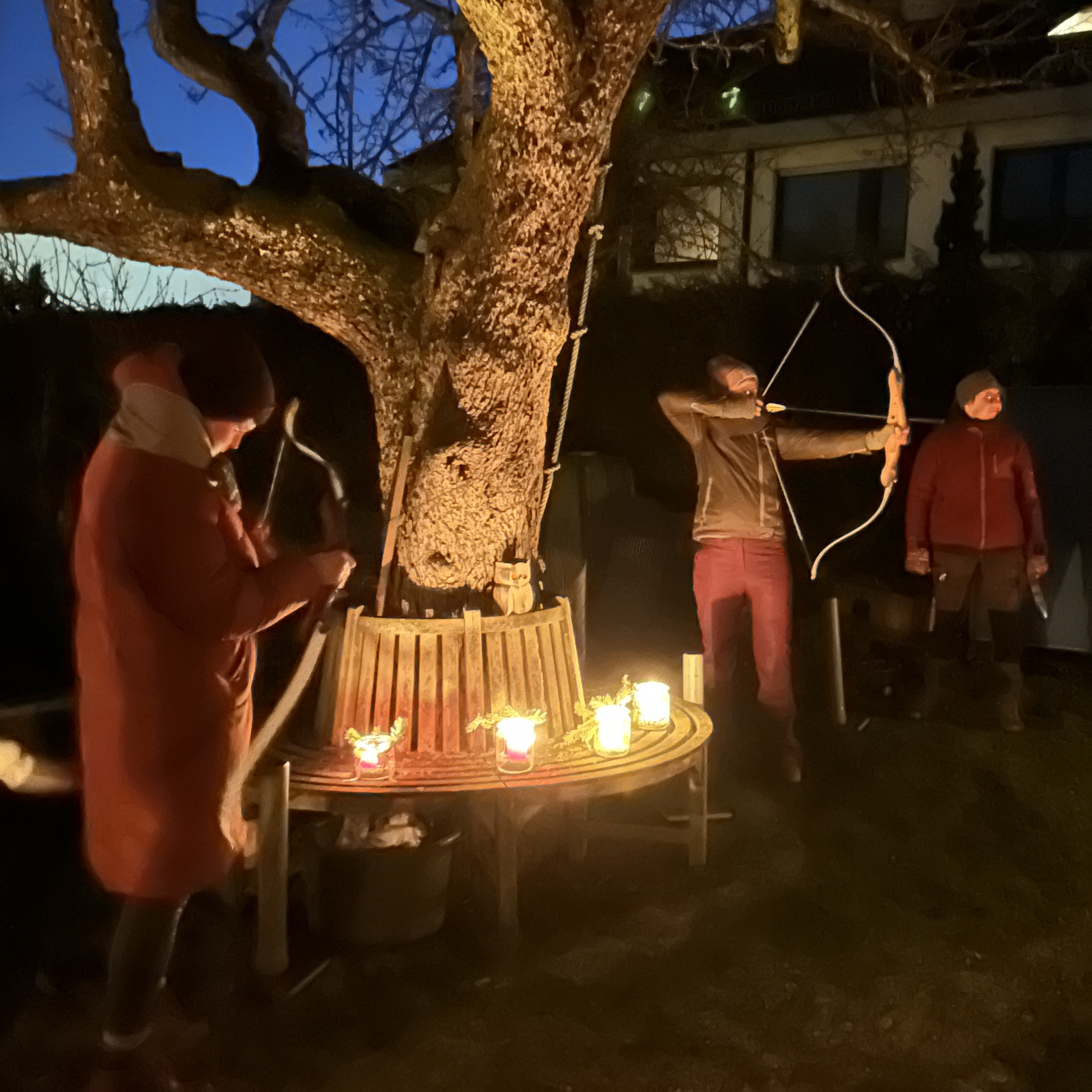 Bogenschützin im Dunkeln vor Baum