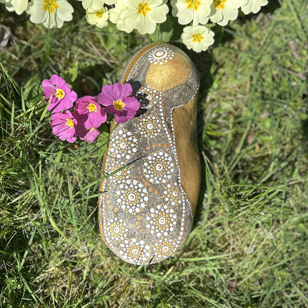 Bemalter Stein mit Engel zwischen Blumen