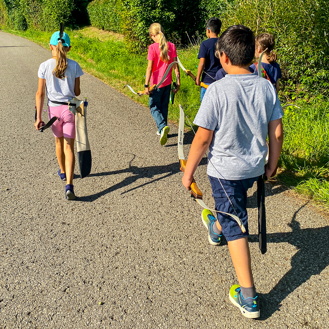 Kinder auf dem Weg zum Bogenschießen
