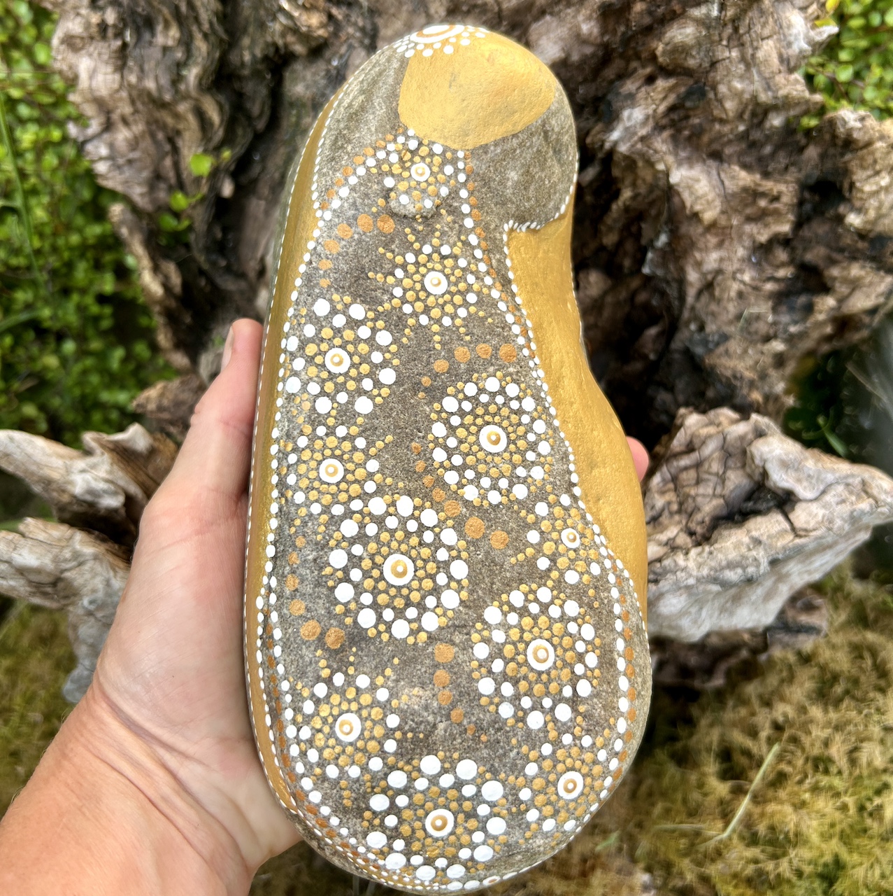 Bemalter Stein mit Engel in der Hand