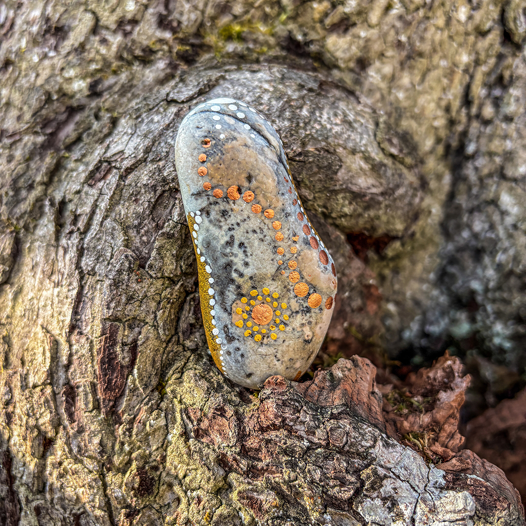 Bemalter Stein vor Rinde