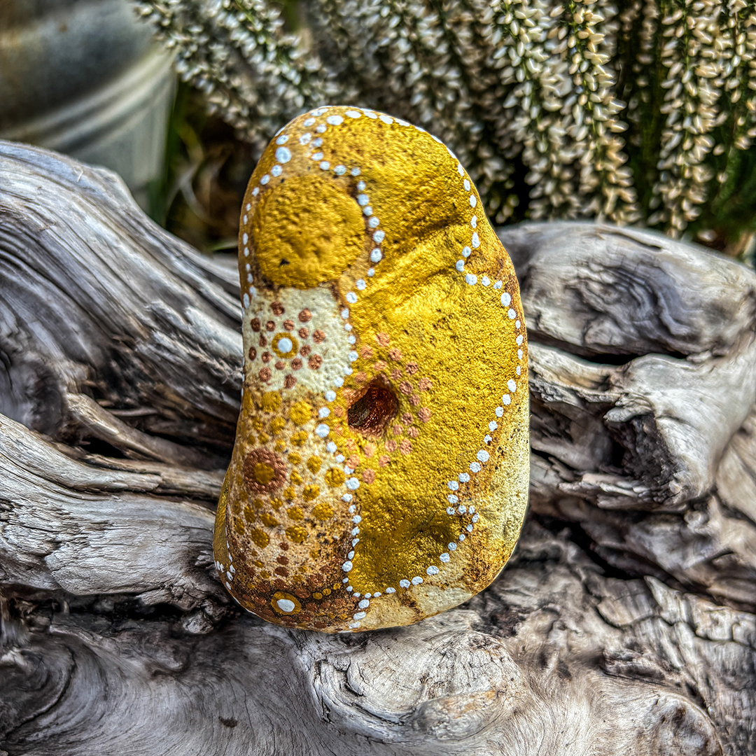 Bemalter Stein mit Engel vor weißer Erikapflanze