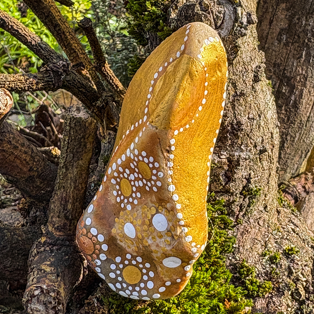 Bemalter Stein mit Engel vor Astgabel