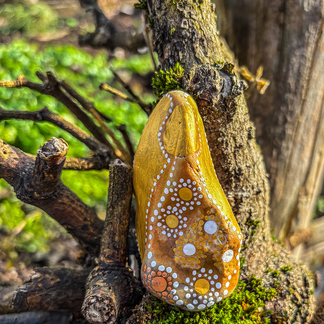 Bemalter Stein mit Engel vor Astgabel
