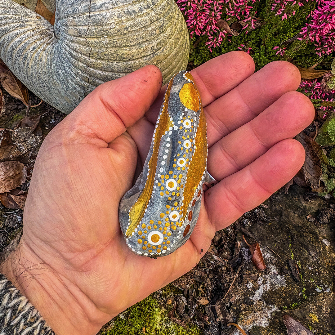 Bemalter Stein mit Engel in Handfläche liegend