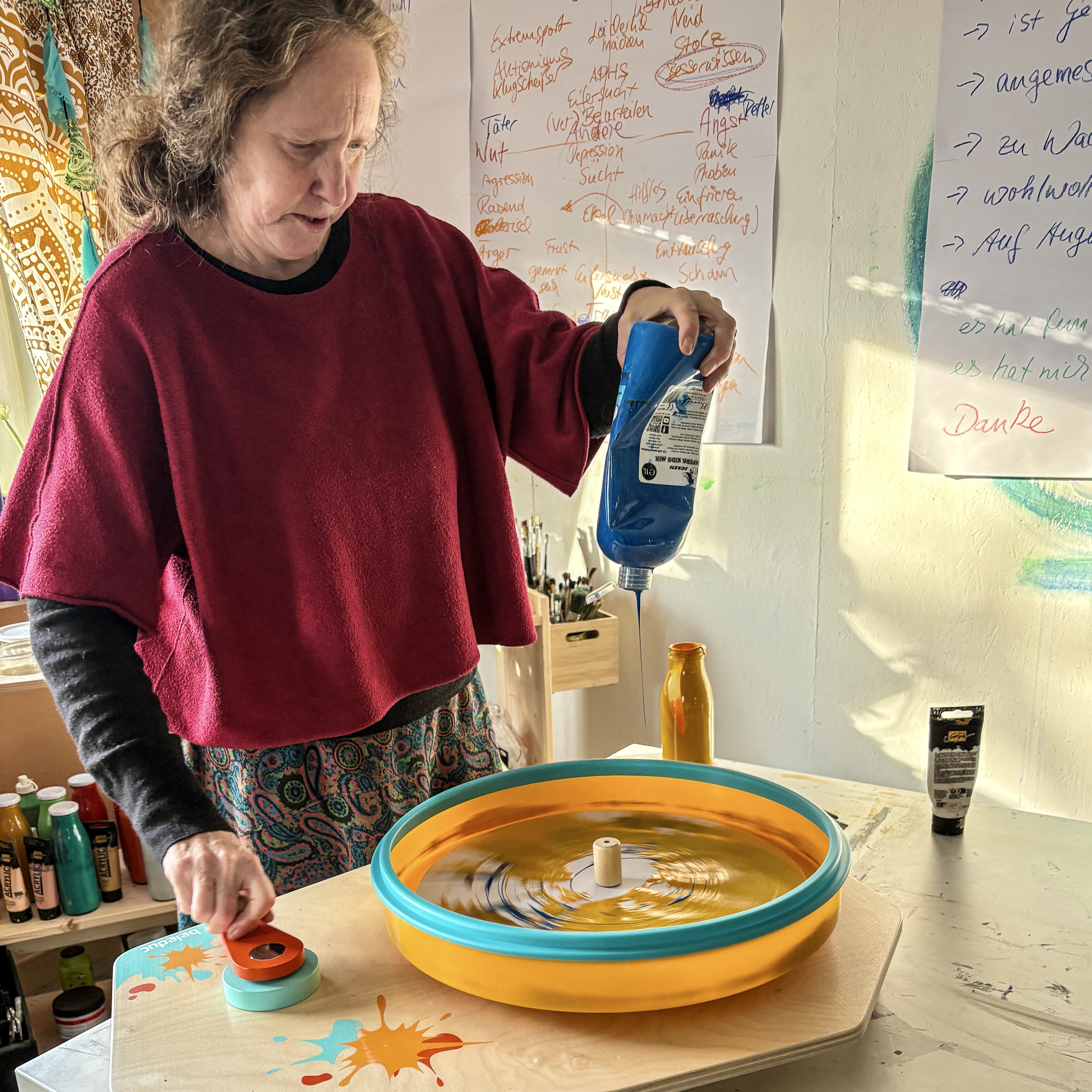 Frau mit blauer Farbflasche in. der Hand, die Farbschleuder bedient