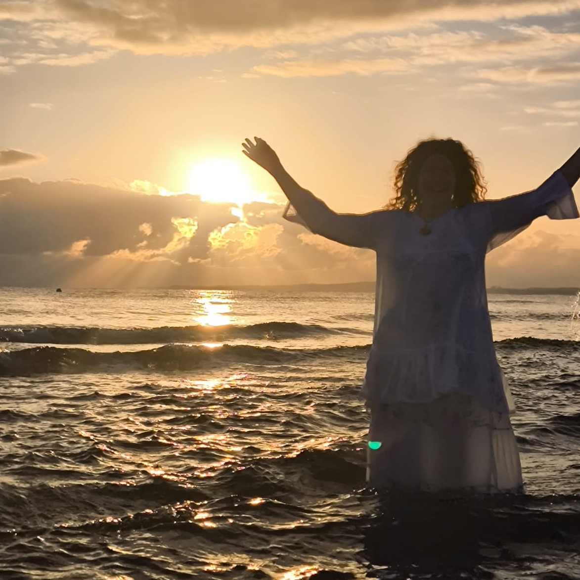 Frau am Strand bei Sonnenaufgang