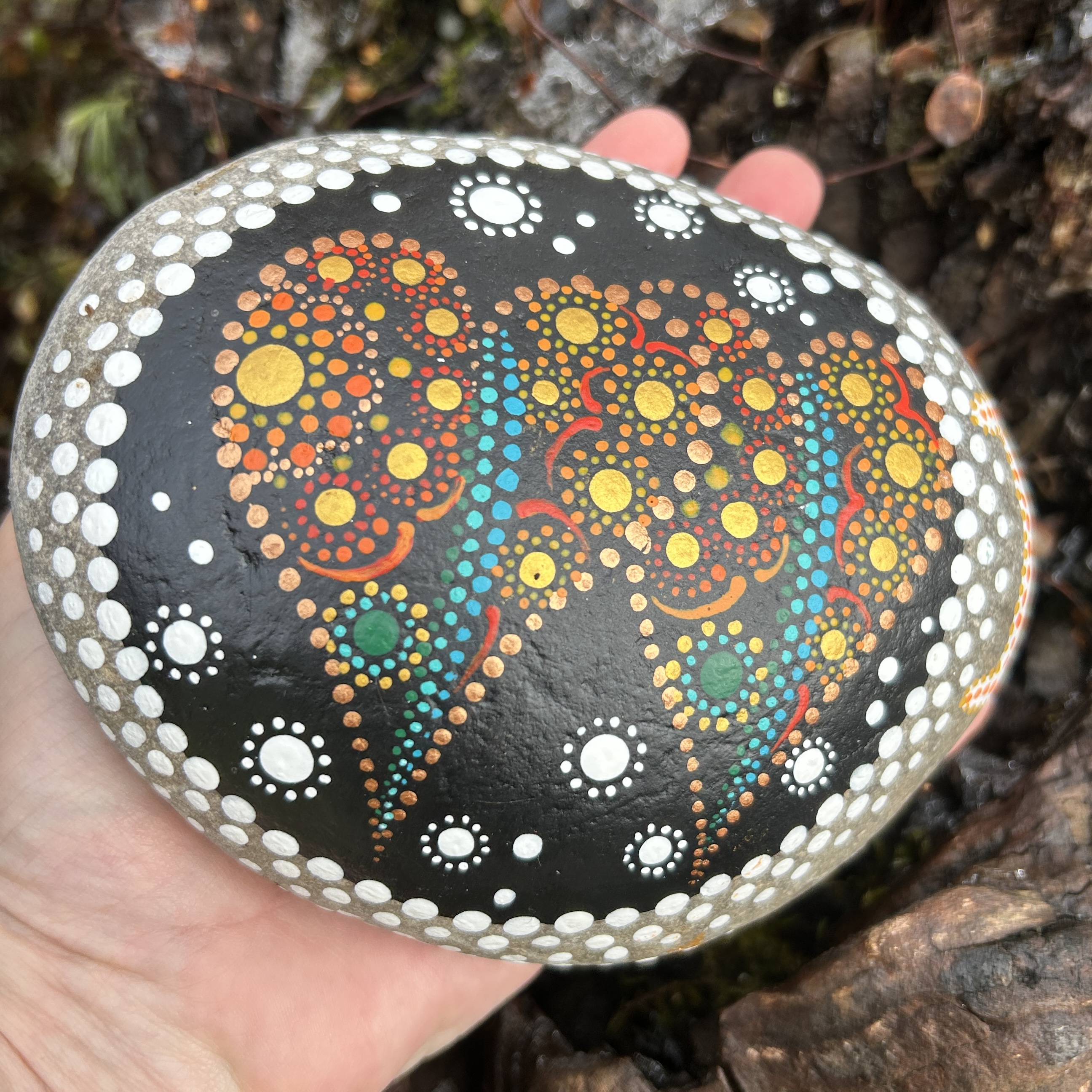 Stein mit zwei Herzen in Dot Painting Technik mit Acrylfarbe gestaltet wird in der Hand gehalten