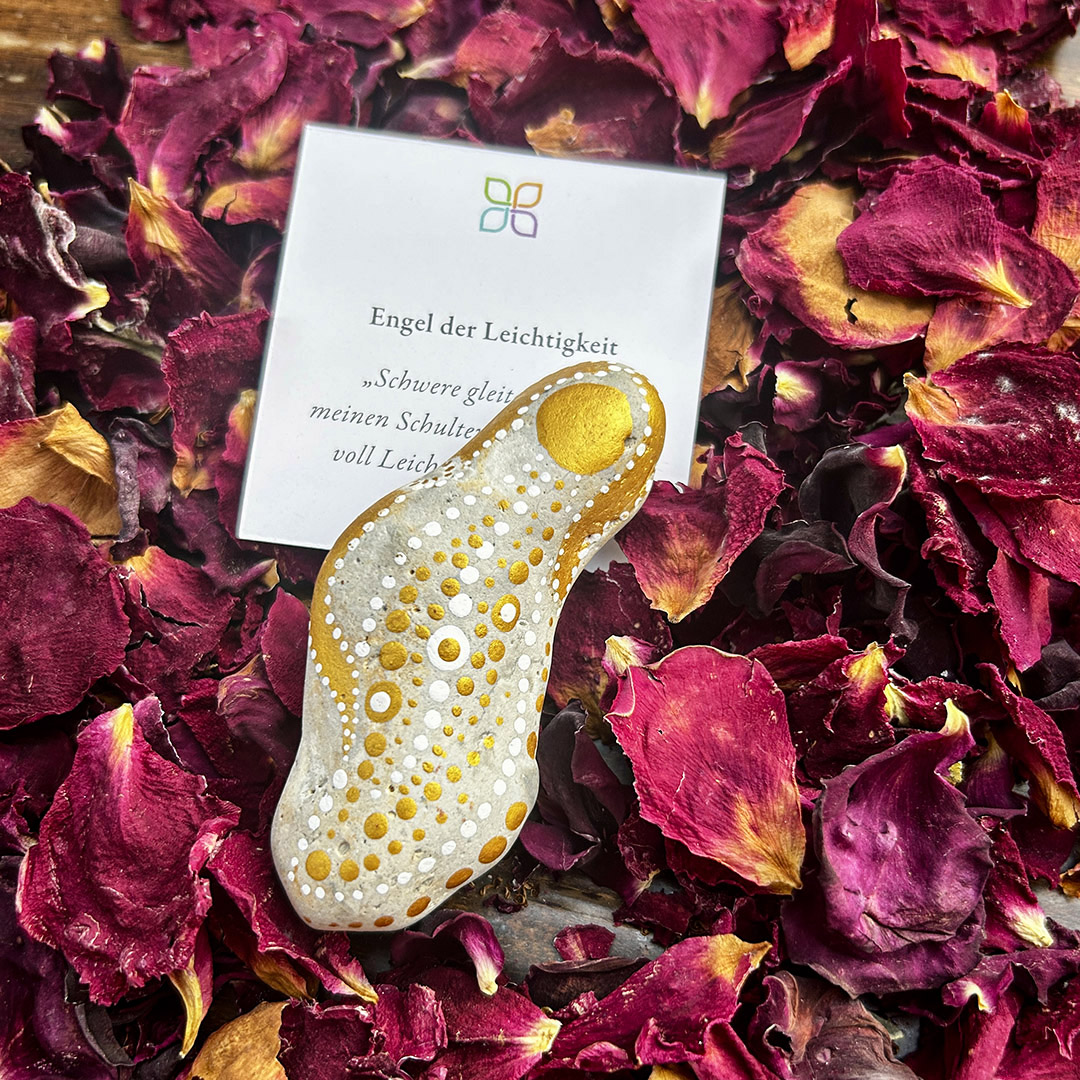 Bemalter Stein mit Engel auf Rosenblätter