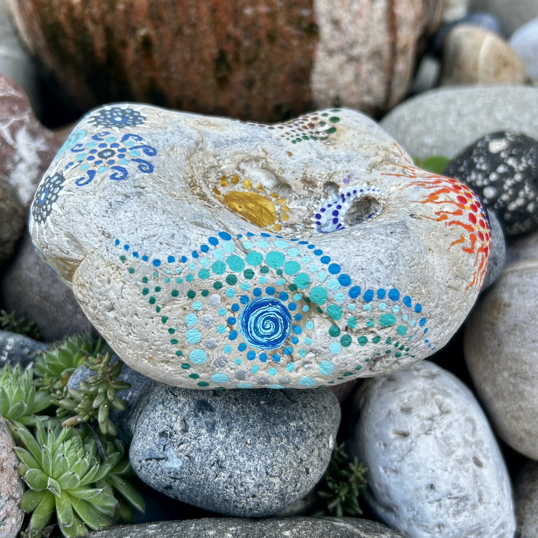 Heller Stein mit Mandalas gestaltet, im Detail das Element Wasser zu sehen