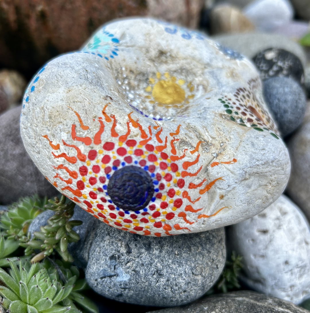 Heller Stein mit Mandalas gestaltet, im Detail das Element Feuer zu sehen