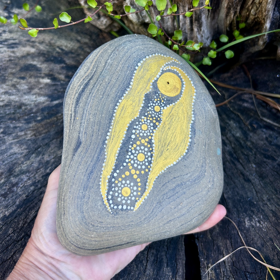 Stein mit einem Engel bemalt in der Hand gehalten