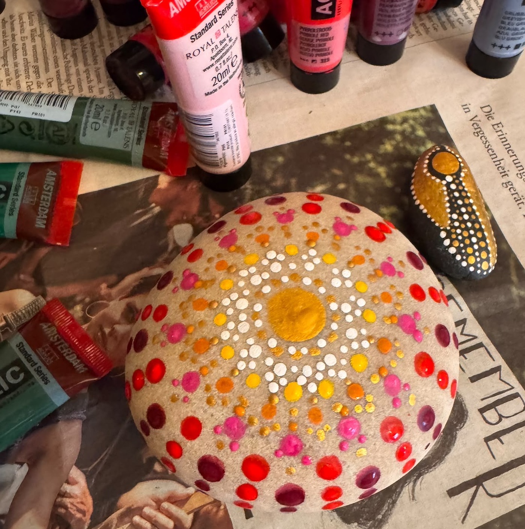 Ein in Dot Painting Technik gestalteter Stein mit Mandalamuster