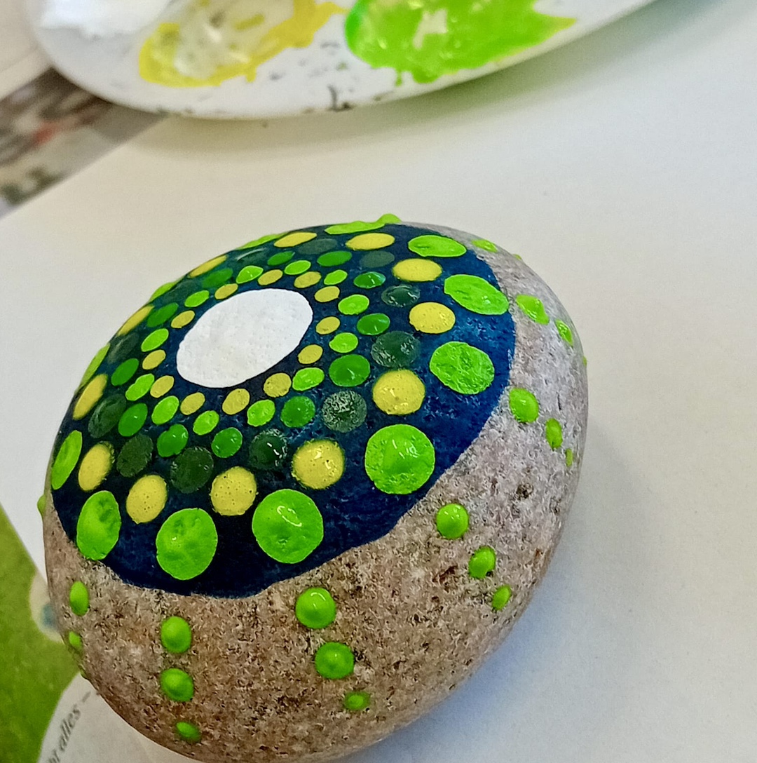 Ein in Dot Painting Technik gestalteter Stein mit Mandalamuster