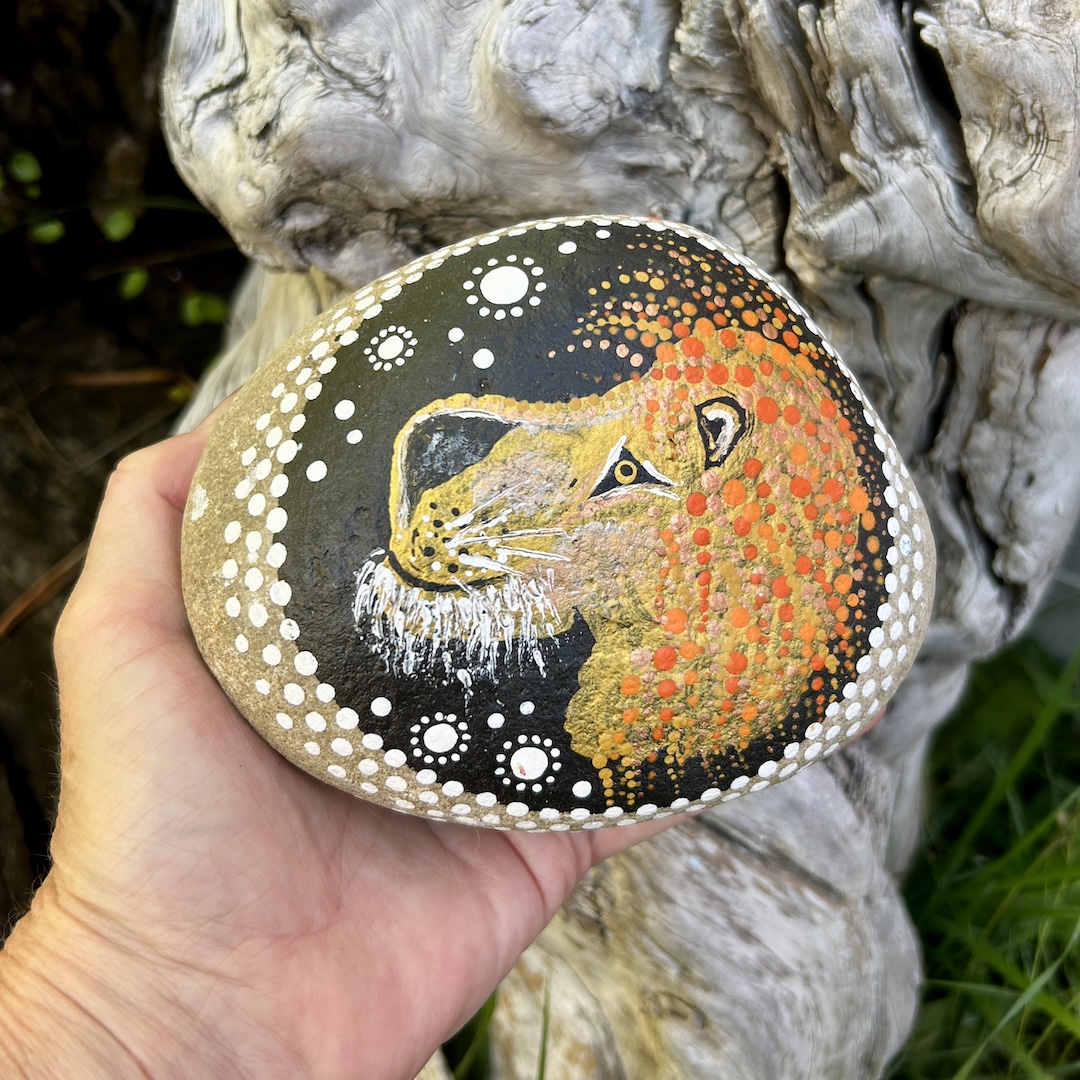 Stein mit dem Sternzeichen Löwe in der Hand liegend
