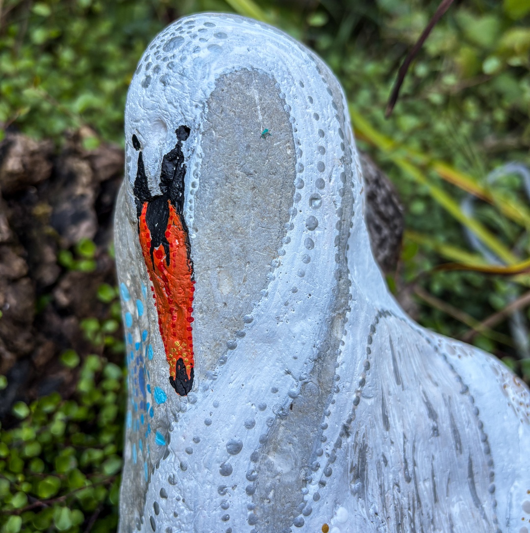 Heller Stein mit einem Schwan bemalt im Detail sieht man den Kopf