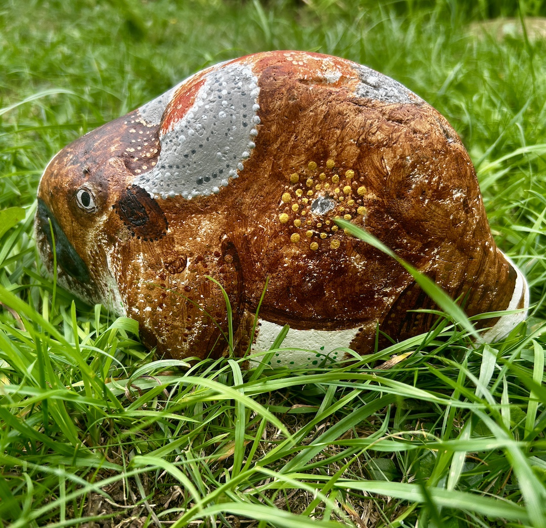 Stein bemalt in Acrylfarbe mit Bison auf grüner Wiese