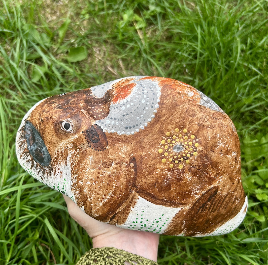 Stein bemalt in Acrylfarbe mit Bison in der Hand gehalten