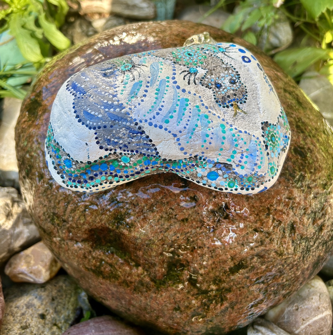 Stein im Garten liegend mit einem Drachen bemalt