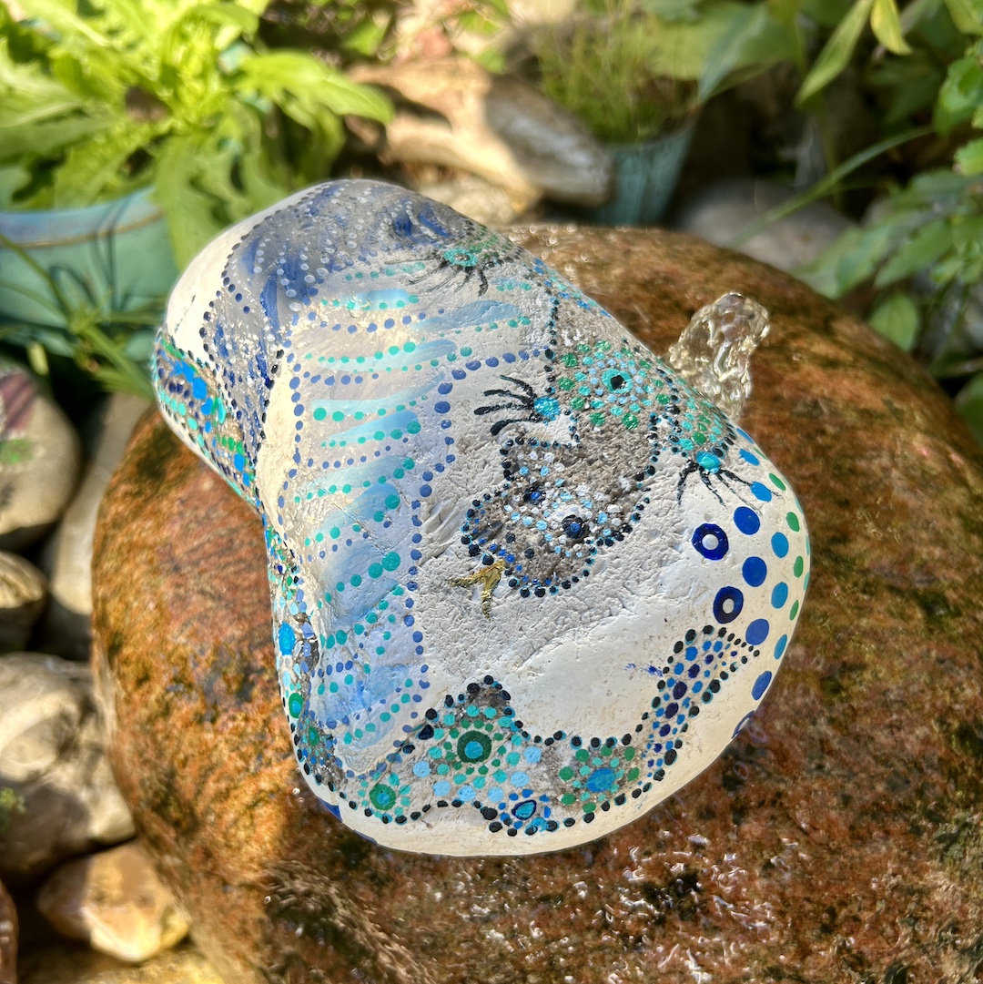 Stein im Garten liegend mit einem Drachen bemalt