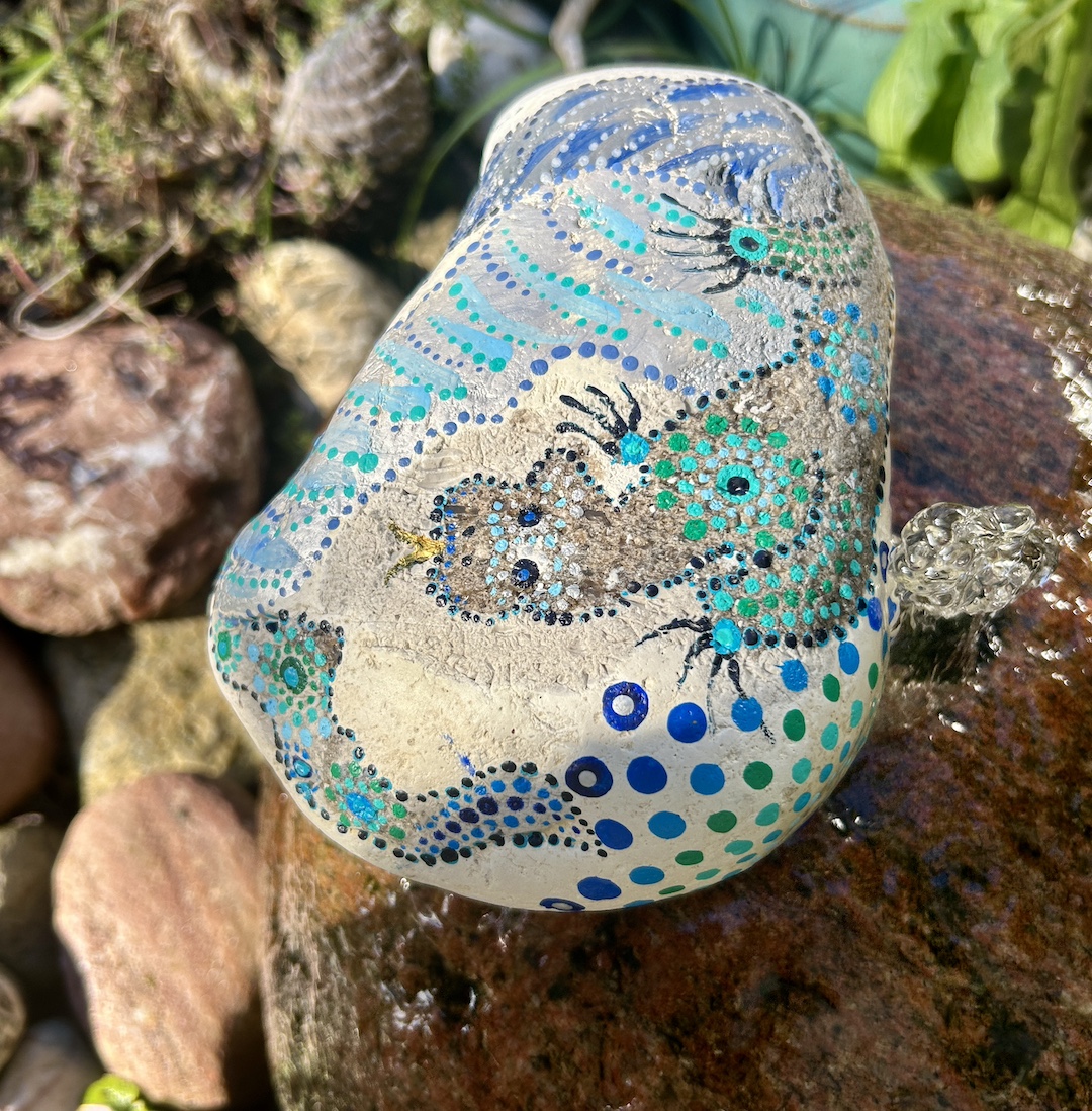 Stein im Garten liegend mit einem Drachen bemalt