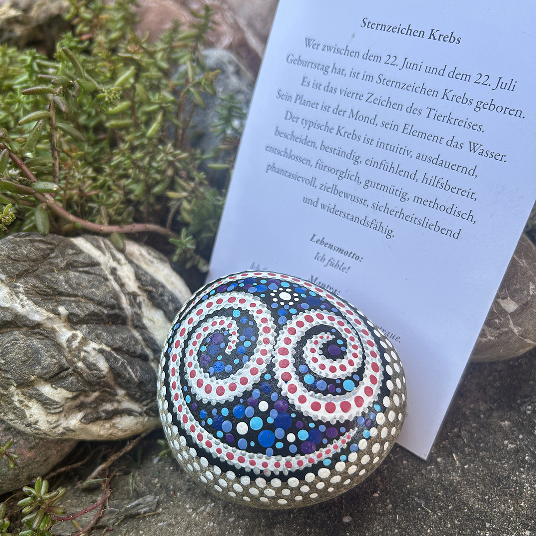 Bemalter Stein mit astrologischen Symbol Krebs mit Begleittext