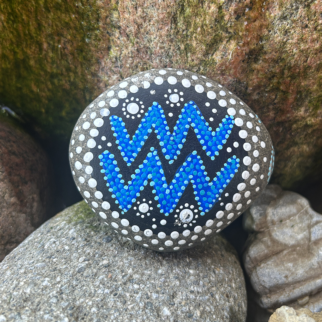 Bemalter Stein mit astrologischen Symbol Wassermann