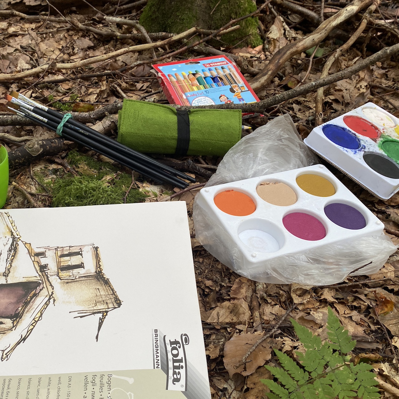 Farben und Zeichenblock im Wald