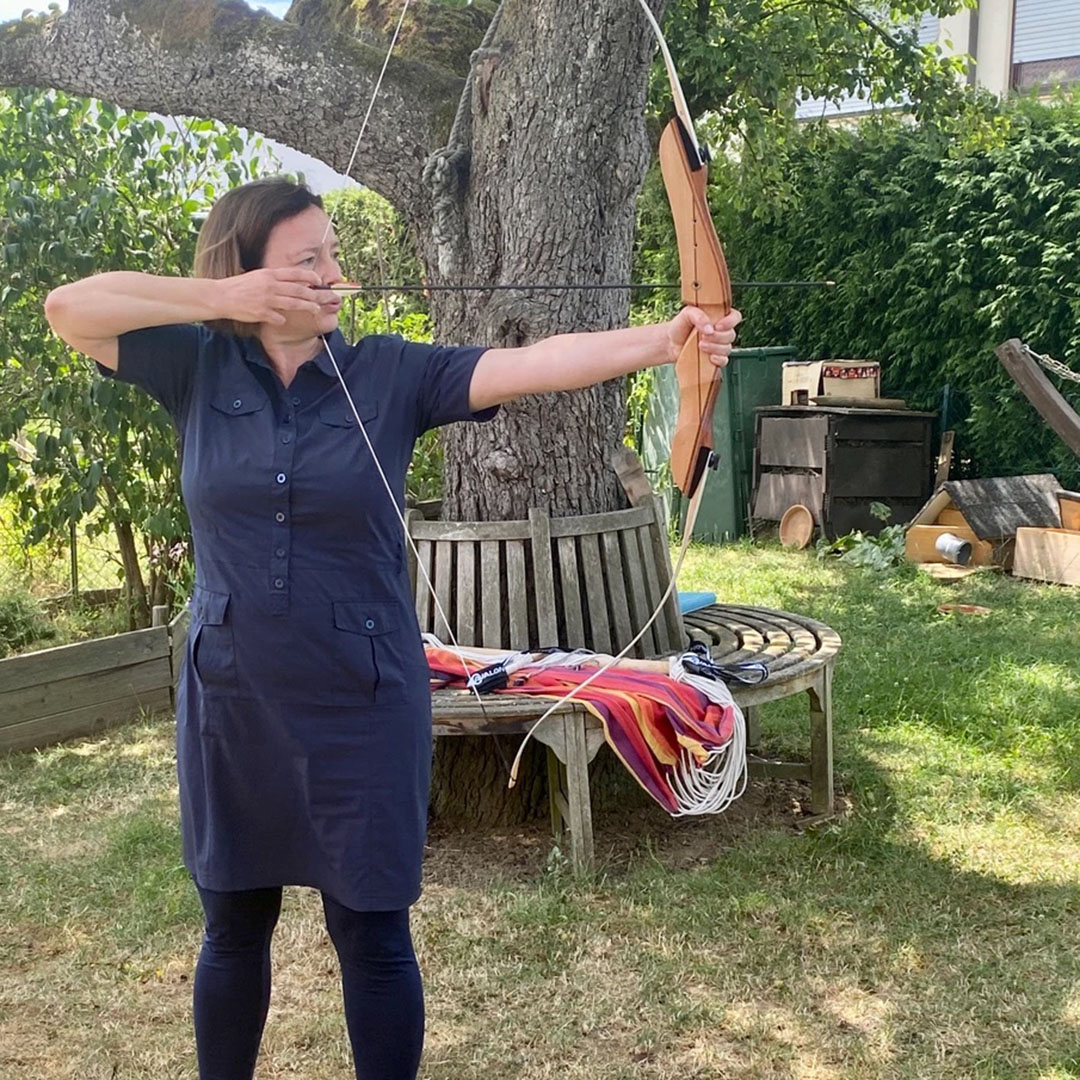 Frau mit Pfeil und Bogen in Garten