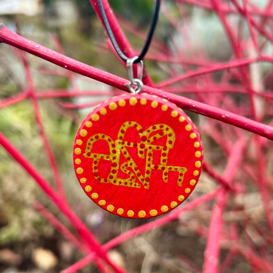 Amulett aus Holzscheibe mit Buchstaben 