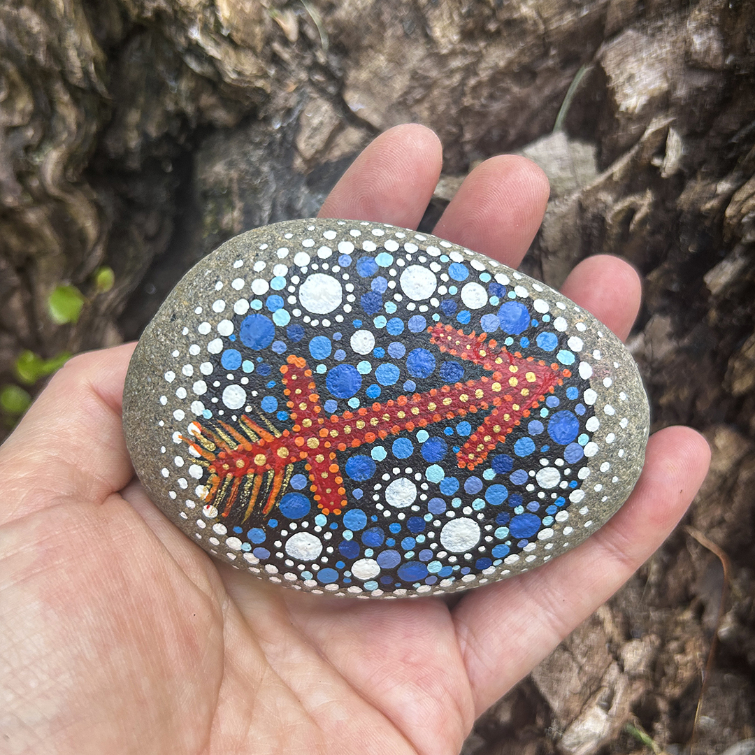 Bemalter Stein mit astrologischem Symbol Schütze