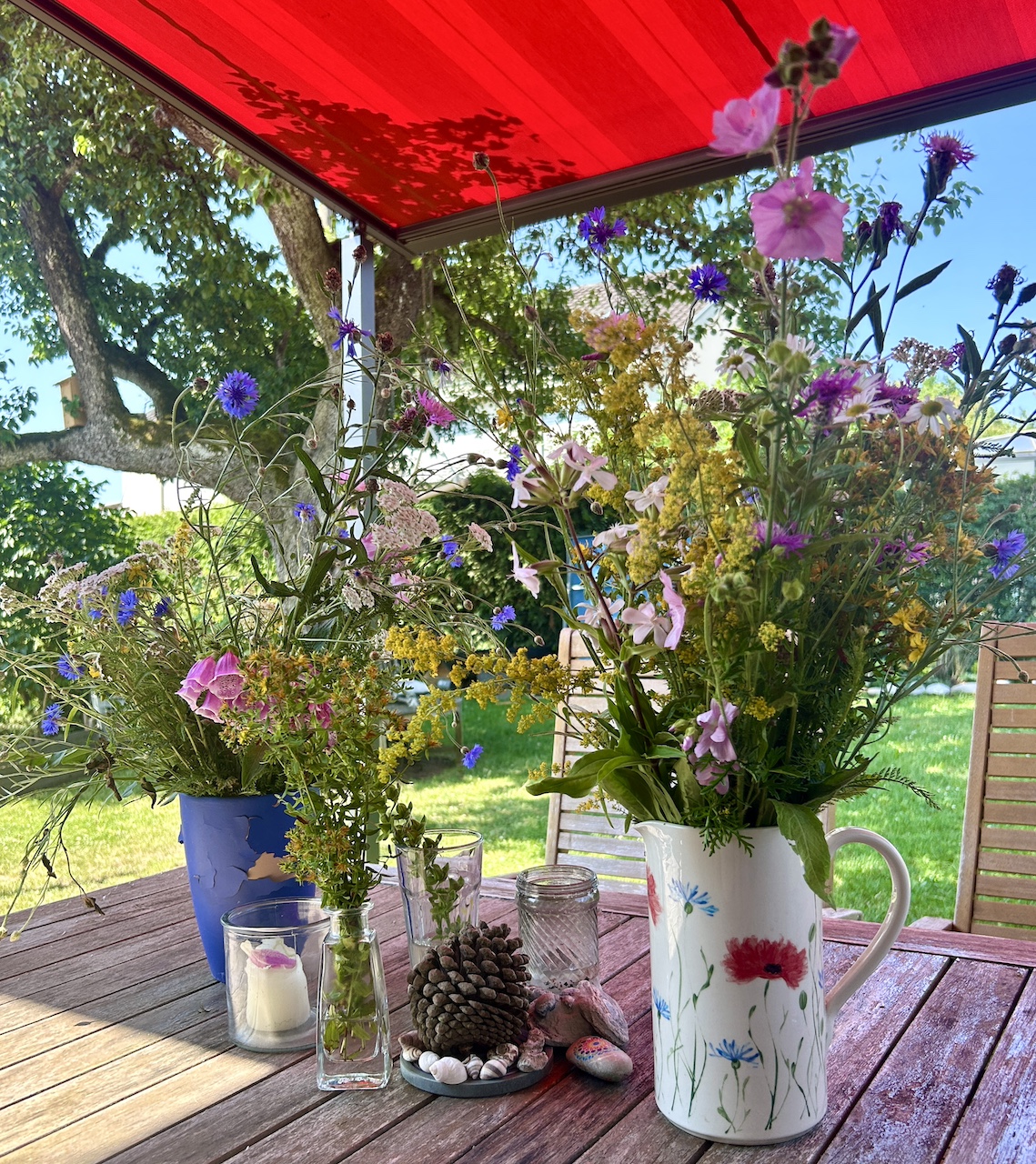 Blumenstrauß in Krug auf Tisch im Freien