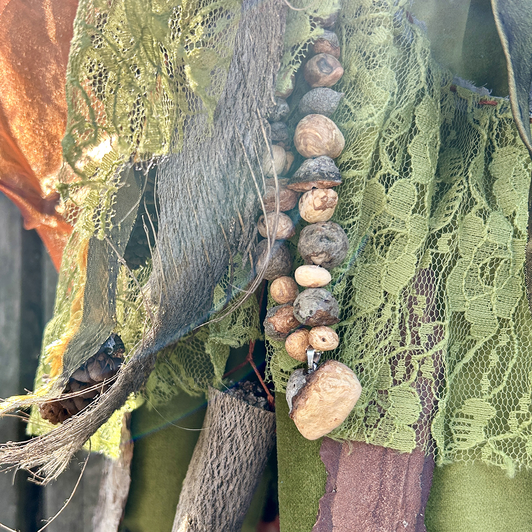 Stabpuppe Rückseite mit Kette aus Baumperlen