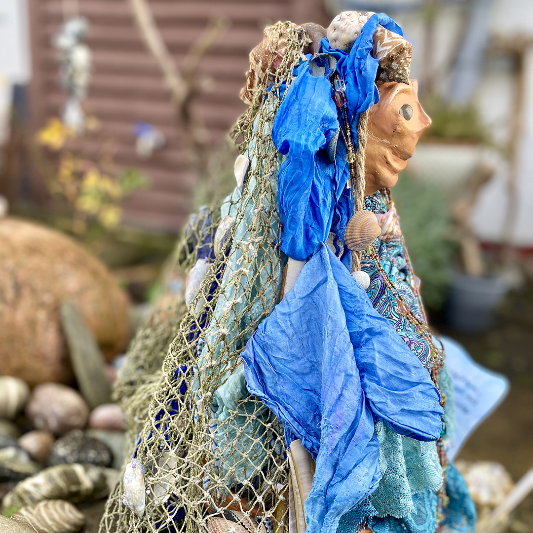Stabfigur mit Accesoires des Meeres geschmückt und Fischernetz seitlich